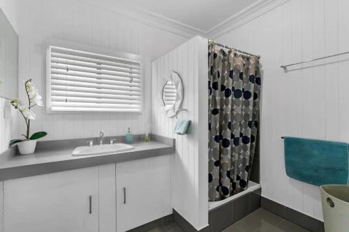 łazienka z umywalką i zasłoną prysznicową w obiekcie River Life w mieście Wellington East