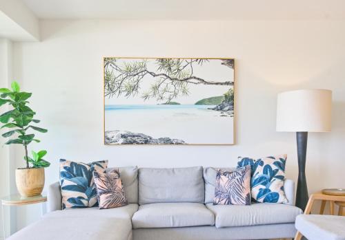 a living room with a couch and a painting on the wall at Noosa Crest Penthouse 40 - Private Rooftop Pool in Noosa Heads