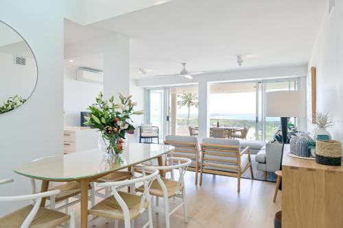 a dining room and living room with a table and chairs at Noosa Crest Penthouse 40 - Private Rooftop Pool in Noosa Heads