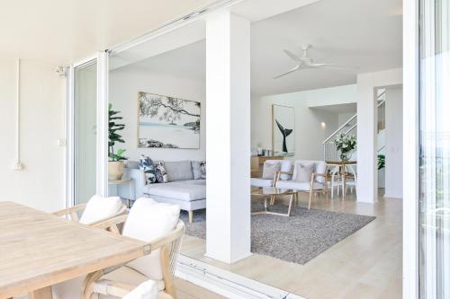 a white living room with a table and chairs at Noosa Crest Penthouse 40 - Private Rooftop Pool in Noosa Heads