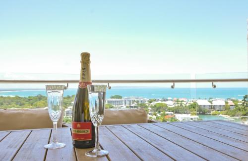 a bottle of champagne and two glasses on a table at Noosa Crest Penthouse 40 - Private Rooftop Pool in Noosa Heads