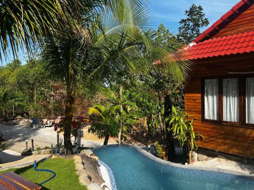 a swimming pool in front of a house with a resort at Ong Huong House Can 2 in Phu Quoc