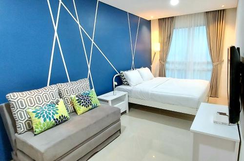 ジャカルタにあるWoodland Park Residence-Relaxed and Friendlyのベッドルーム1室(ベッド1台、ソファ付)
