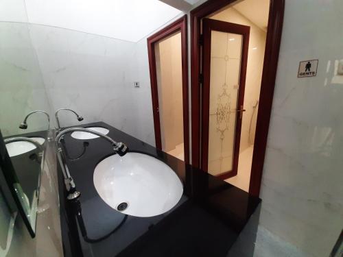 a bathroom with a white sink and a mirror at Kawa Living in Krukah