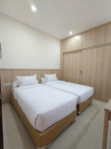 a bedroom with a large white bed in a room at Kawa Living in Krukah