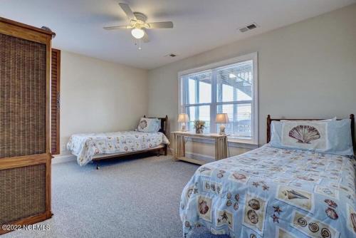 een slaapkamer met 2 bedden en een raam bij Beautiful 4 bed 3 bath beach cottage with wonderful ocean views in Surf City