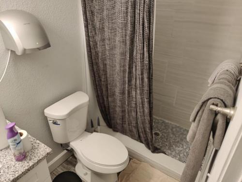 a bathroom with a toilet and a shower at Roosevelt Inn in Jacksonville