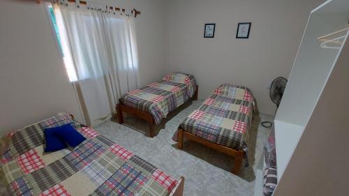 a room with two twin beds and a window at Casa con pileta privada in General Alvear