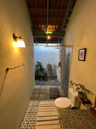 ein Bad mit Dusche, WC und Tür in der Unterkunft Araliya Villa by Ella Nine Peaks in Ella