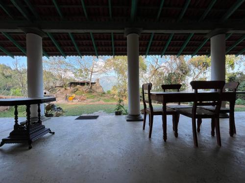 a porch with a table and chairs and a view at Ella Nine Peaks in Ella