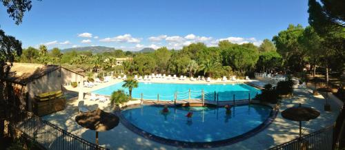 une vue aérienne d'une piscine dans un complexe hôtelier dans l'établissement Greenchalets Camp Lei Suves, Roquebrune sur Argens ( Provence- Cote d'azur), à Roquebrune-sur Argens