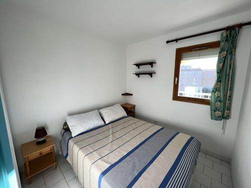 mała sypialnia z łóżkiem i oknem w obiekcie Appartement avec Piscine, Parking Privé, Lave-Vaisselle – À 150m de la Plage - FR-1-702-36 w Cap d'Agde