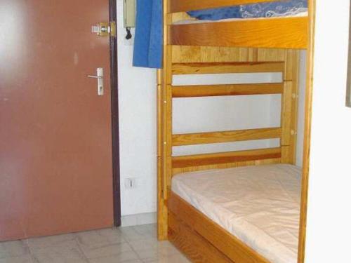 Cette chambre comprend 2 lits superposés et une porte. dans l'établissement Studio Cabine Vue Mer pour 4 à Valras-Plage - FR-1-701-42, à Valras-Plage