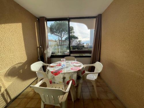 une table et des chaises dans une pièce avec une fenêtre dans l'établissement Appartement climatisé 4 pers, proche plage, loggia, parking sécurisé, St-Cyprien - FR-1-225D-157, à Saint-Cyprien