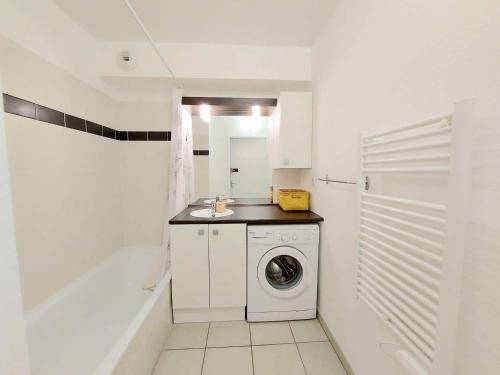 une salle de bain blanche avec une machine à laver et un lavabo dans l'établissement Appartement 2 pièces avec accès direct plage, piscine et terrasse - Marseillan - FR-1-326-778, à Marseillan