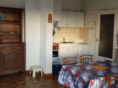 une cuisine avec une table et des chaises dans une pièce dans l'établissement T2 avec Parking, Grande Terrasse, Chambre et Proche Plage - Quartier Môle - FR-1-702-37, au Cap d'Agde