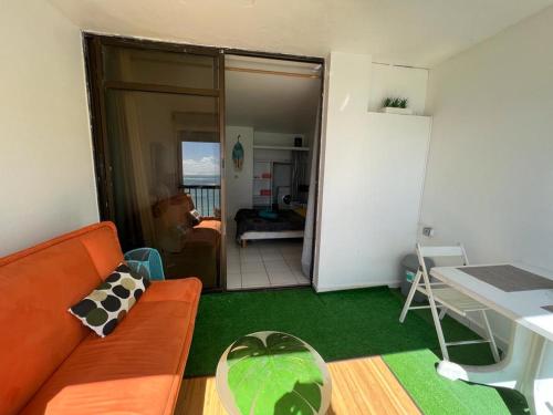 ein Wohnzimmer mit einem Sofa und einem Tisch in der Unterkunft OCEANE 2 in Le Gosier