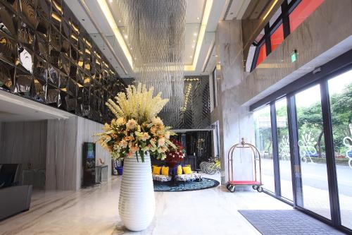 a lobby with a large vase with flowers in it at 冠月精品旅館-Puli Ease Hotel in Puli