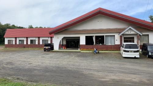 a house with two cars parked in front of it at ビジネスホテル幸楽 in Abashiri