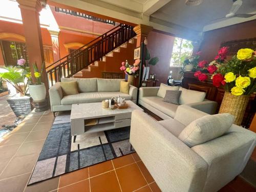 uma sala de estar com sofás, uma mesa e flores em Siemreap Nitnit Boutique em Phumĭ Kngan Pông