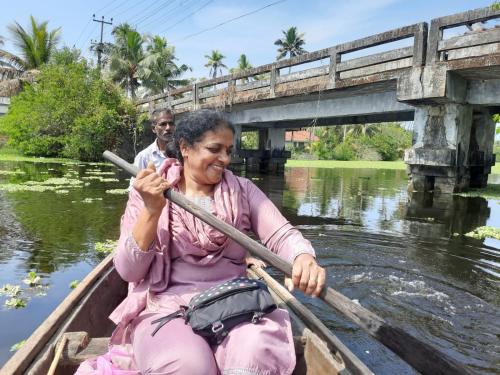 a woman in a boat on the water at Marari Bethsaida Homestay in Shertallai