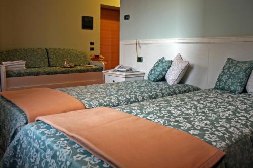 a hotel room with two beds and a couch at Country House La Perla del Sile in Sant'Elena di Silea