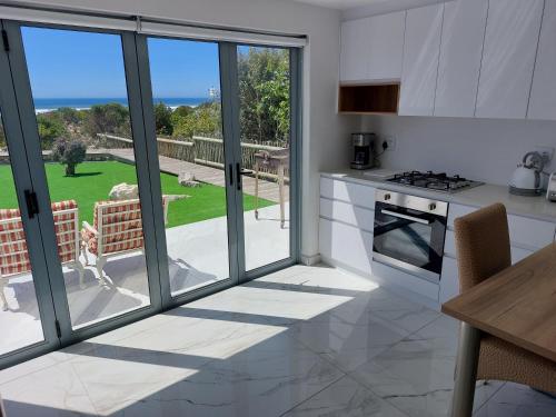 a kitchen with sliding glass doors and a view of a yard at Soli Deo Gloria, Pearl Studio in Paternoster