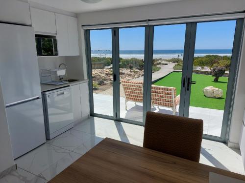 a kitchen and dining room with a view of the ocean at Soli Deo Gloria, Pearl Studio - Solar in Paternoster