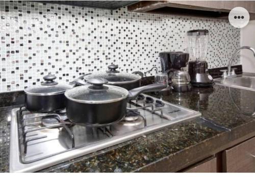 three pots sitting on top of a stove in a kitchen at NAMASTE ELEAN 2A in Cali