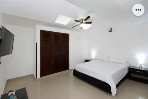 NAMASTE ELEAN 2A في كالي: غرفة نوم بسرير ومروحة سقف