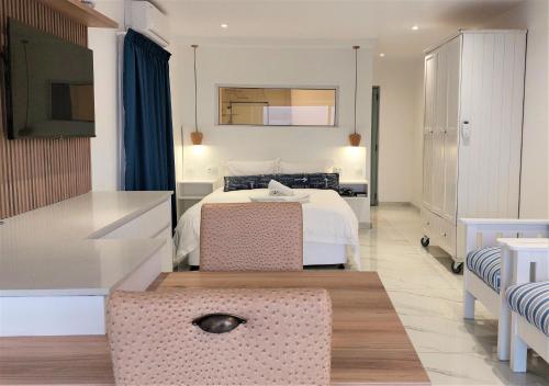 a bedroom with a bed and a table and a kitchen at Soli Deo Gloria, Pearl Studio in Paternoster