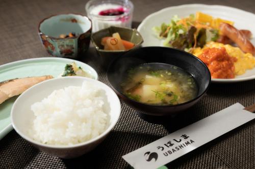 a table topped with plates of food and bowls of rice at Ubasima inn in Minami Uonuma