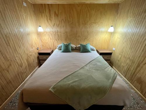 a bedroom with a large bed with two night stands at Refugio El Chucao in Hornopiren
