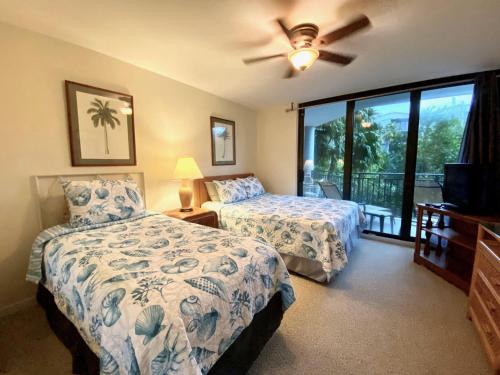 a bedroom with two beds and a ceiling fan at Tropical Paradise Key West in Key West