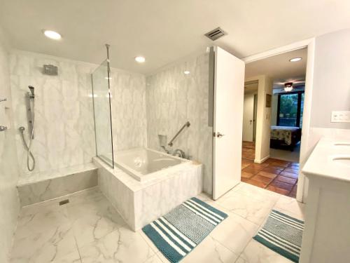 a white bathroom with a tub and a shower at Tropical Paradise Key West in Key West