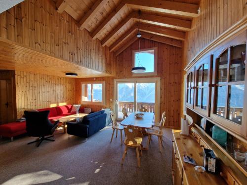 a living room with a table and a couch at Bettmeralp Chalet Zendorn in Bettmeralp