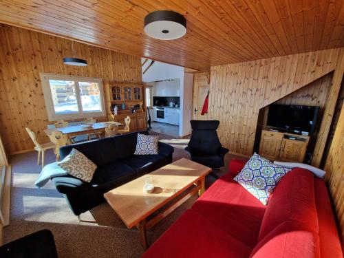 a living room with a couch and a table at Bettmeralp Chalet Zendorn in Bettmeralp