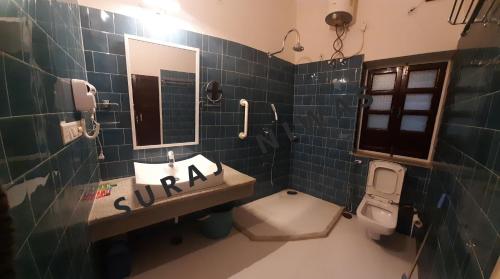 y baño con lavabo, aseo y espejo. en Suraj Niwas, en Jaipur