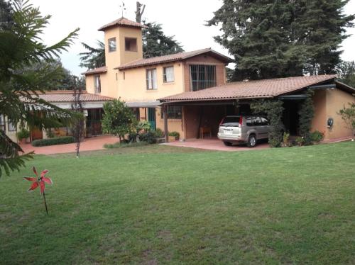 a house with a car parked in the yard at Casa Campestre del Mangrullo in Mexico City