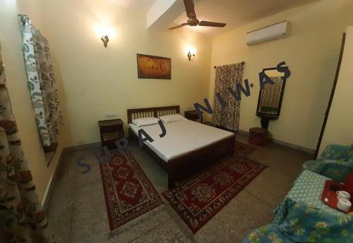 sala de estar con cama y alfombra en Suraj Niwas, en Jaipur