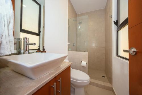 a bathroom with a white sink and a toilet at Casa Amor in Puerto Vallarta