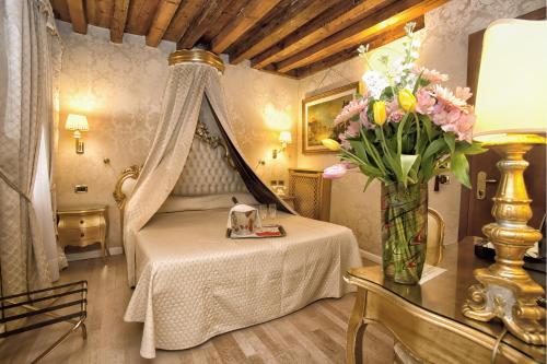 威尼斯的住宿－諾埃米酒店，一间卧室,配有一张带花瓶的床