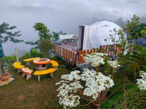 a garden with a table and chairs and a tent at Khao Kho Tree Top in Khao Kho