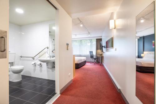 a bathroom with a toilet and a sink in a room at Holiday Inn Melbourne Airport, an IHG Hotel in Melbourne