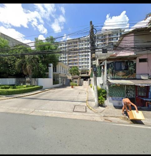 a person holding a box on the side of a street at OYO 923 Cozy Crib By Shey in Manila