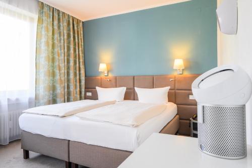 ein Hotelzimmer mit einem Bett und einer Heizung in der Unterkunft Hotel Kaspar Garni in Siegburg