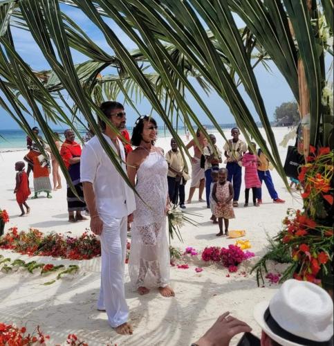 a bride and groom standing under a tent on the beach at Sipano Beach Lodge Kiwengwa in Kiwengwa