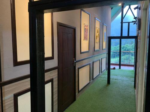 an open door in a hallway with a green carpet at Villa Paiton Bromo in Probolinggo