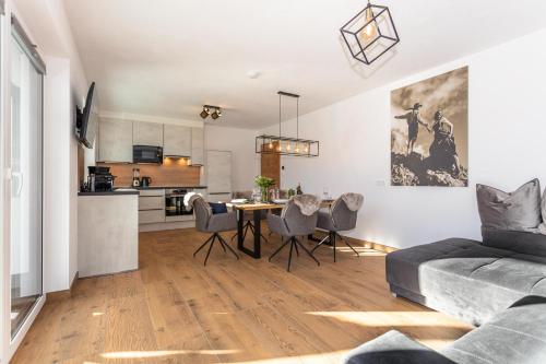 a living room with a table and chairs and a kitchen at Lienbichl in Saalbach Hinterglemm