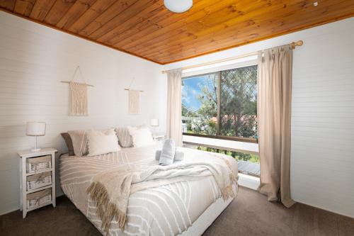 Callala BeachにあるDrifters @ Callala Beachのベッドルーム1室(ベッド1台、大きな窓付)
